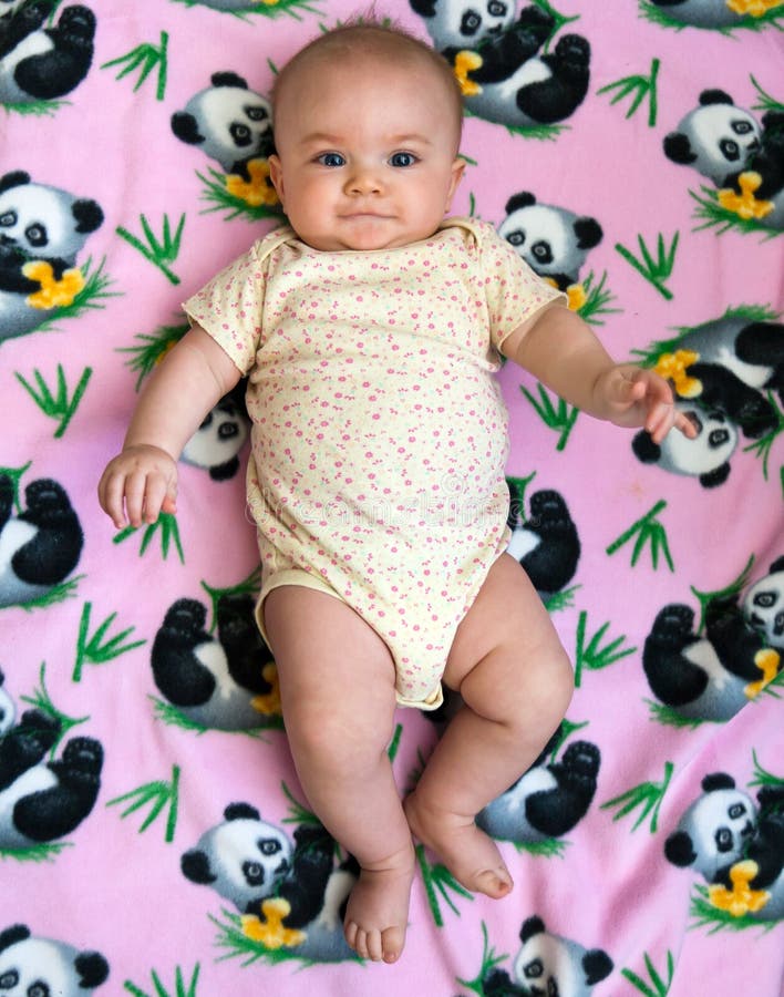 Five month old baby girl posing against a pink panda background. Five month old baby girl posing against a pink panda background.