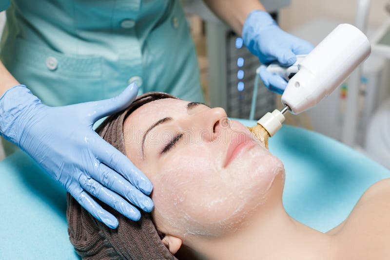 Механически шелушение Beautician делает механически чистку стороны cosmetology стоковое изображение Механически шелушение Beautician делает механически чистку стороны cosmetology стоковое изображение