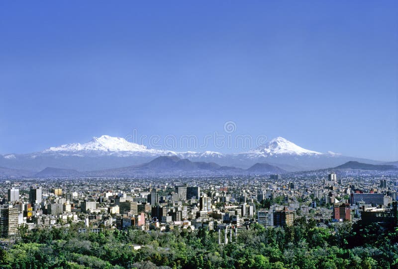 Aerial view of mexico City on a clear day without contamination. In the foreground Chapultepec Park, buildings and skyscrapers in the middle distance, snowed volcanoes on the horizon. Aerial view of mexico City on a clear day without contamination. In the foreground Chapultepec Park, buildings and skyscrapers in the middle distance, snowed volcanoes on the horizon.