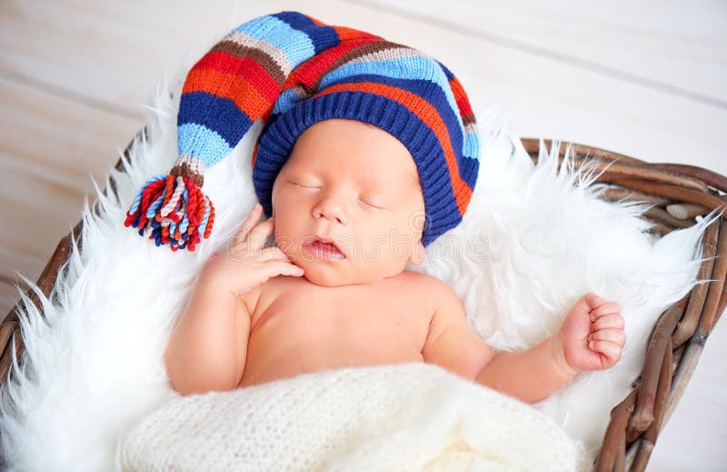 Милый newborn младенец в голубой крышке knit спать в корзине стоковые изображения rf