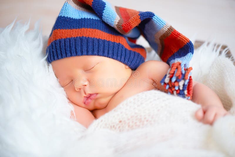 Милый newborn младенец в голубой крышке knit спать в корзине стоковые фотографии rf