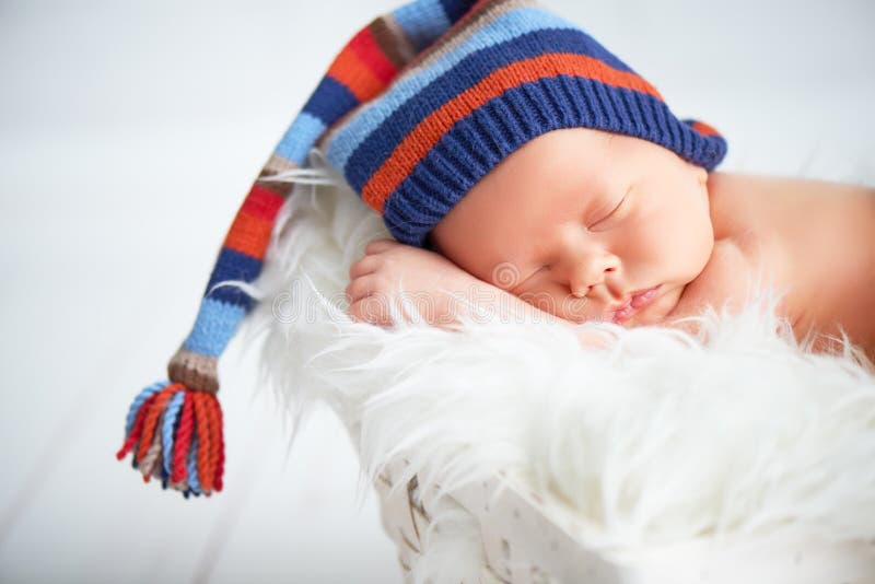 Милый newborn младенец в голубой крышке knit спать в корзине стоковая фотография rf