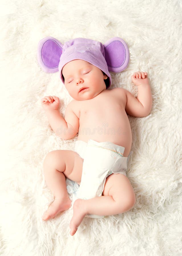 Милый newborn младенец спит в шляпе мыши с ушами