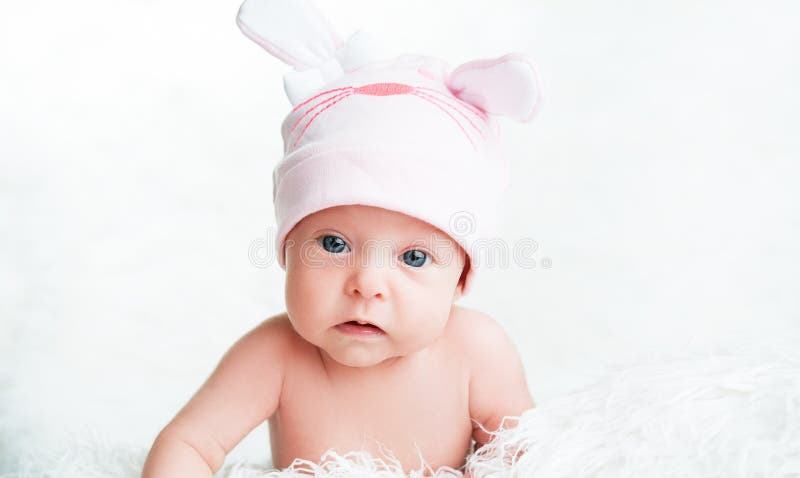 Милый newborn ребёнок в розовой шляпе с ушами стоковые фото
