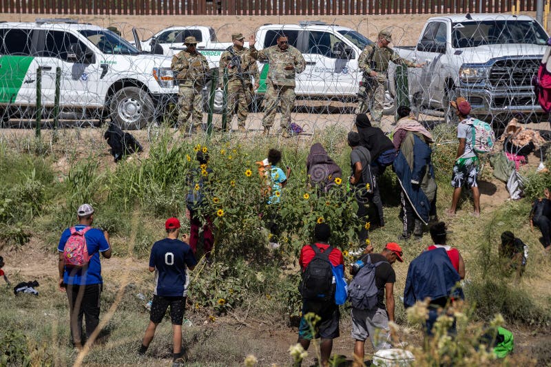 Group of migrants attempting to illegally cross the Mexico and USA border to seek asylum, national guard agents in background, Juarez, Chihuahua, Mexico, October 2nd 2023. Group of migrants attempting to illegally cross the Mexico and USA border to seek asylum, national guard agents in background, Juarez, Chihuahua, Mexico, October 2nd 2023.