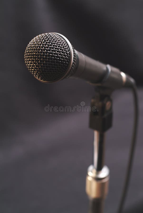 Vocal microphone for singing and speaking against a dark background. Vocal microphone for singing and speaking against a dark background