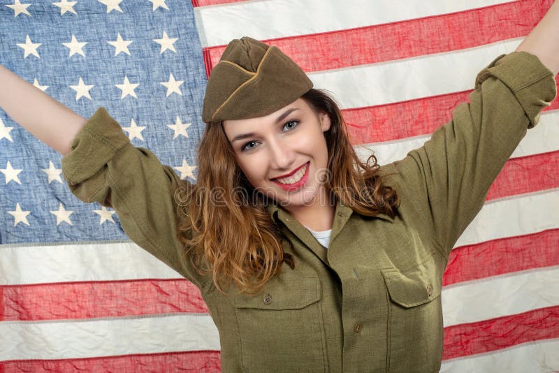Милая молодая женщина в форме wwii мы с американским флагом стоковые изображения rf Милая молодая женщина в форме wwii мы с американским флагом стоковые изображения rf
