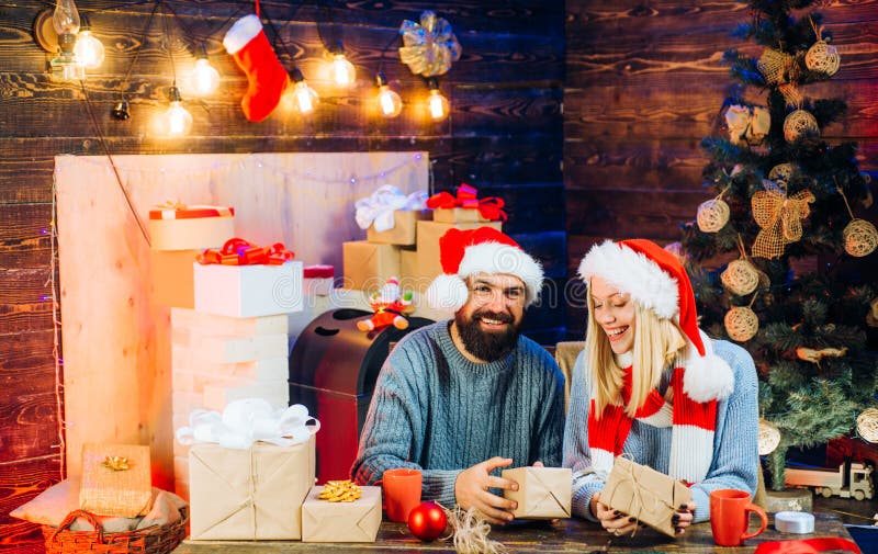 Милая молодая женщина и красивый человек со шляпой santa Любовь Семья Нового Года с коробками подарка на рождество перед стоковые фото Милая молодая женщина и красивый человек со шляпой santa Любовь Семья Нового Года с коробками подарка на рождество перед стоковые фото