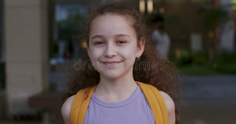 милый портрет ребенка школьница маленькая девочка улыбающийся ребенок глядя на камеру . портрет красивого ребенка с