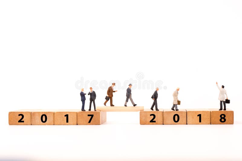 Миниатюрная диаграмма бизнесмен идя на блоке поперек от 2017 до 2018 номера деревянном стоковые фото Миниатюрная диаграмма бизнесмен идя на блоке поперек от 2017 до 2018 номера деревянном стоковые фото