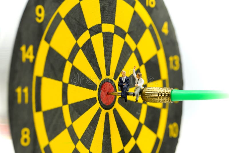 Миниатюрные люди: бизнесмен на стрелке дротика ударяя в центре dartboard, деле цели, достигает и концепции цели победы стоковое изображение rf Миниатюрные люди: бизнесмен на стрелке дротика ударяя в центре dartboard, деле цели, достигает и концепции цели победы стоковое изображение rf