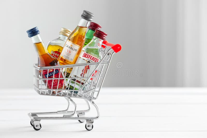 Minsk, Belarus - January 16, 2018: mini shopping cart full of small alcohol bottles - Jameson whiskey, Camus and Martell cognacs, Havana club rum, Beefeater gin. Minsk, Belarus. Minsk, Belarus - January 16, 2018: mini shopping cart full of small alcohol bottles - Jameson whiskey, Camus and Martell cognacs, Havana club rum, Beefeater gin. Minsk, Belarus.