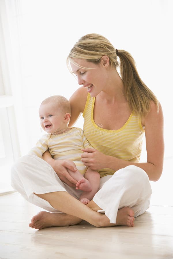 Mother and baby sitting indoors smiling. Mother and baby sitting indoors smiling