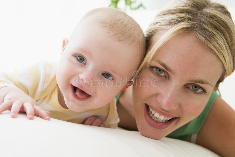 Mother and baby indoors smiling at camera. Mother and baby indoors smiling at camera