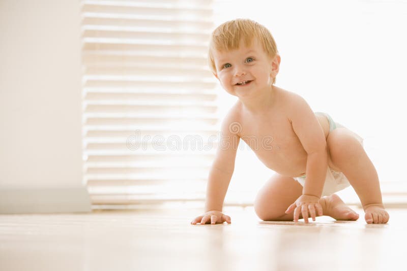 Baby crawling indoors smiling smiling. Baby crawling indoors smiling smiling