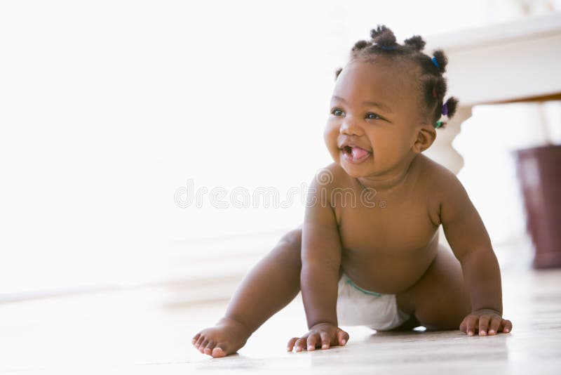 Baby crawling indoors smiling looking away from camera. Baby crawling indoors smiling looking away from camera