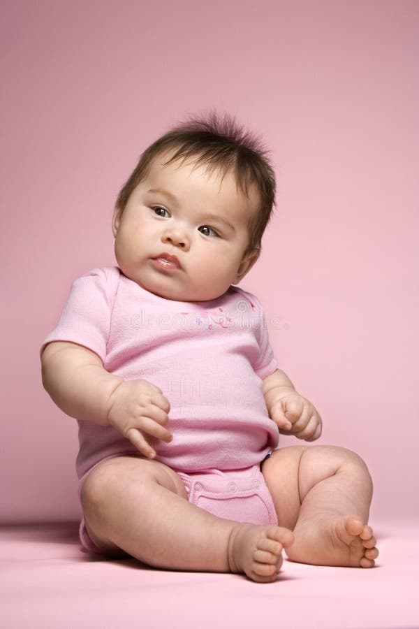 Asian baby sitting up and looking to side. Asian baby sitting up and looking to side.