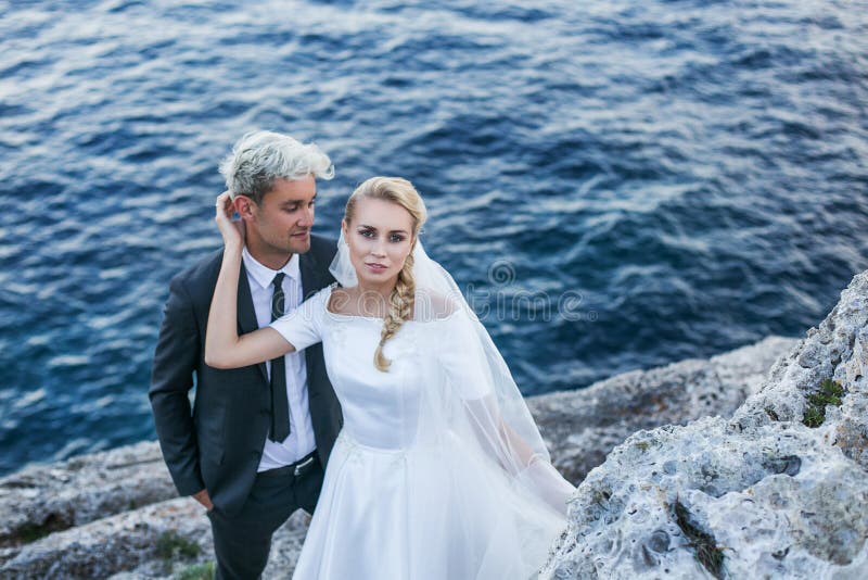 Модные пары свадьбы приближают к океану венчание groom церков церемонии невесты напольный портрет стоковые изображения rf Модные пары свадьбы приближают к океану венчание groom церков церемонии невесты напольный портрет стоковые изображения rf