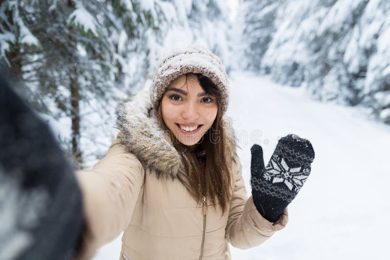 Молодая азиатская красивая камера улыбки женщины принимая фото Selfie в девушке леса снега зимы Outdoors стоковые изображения rf Молодая азиатская красивая камера улыбки женщины принимая фото Selfie в девушке леса снега зимы Outdoors стоковые изображения rf
