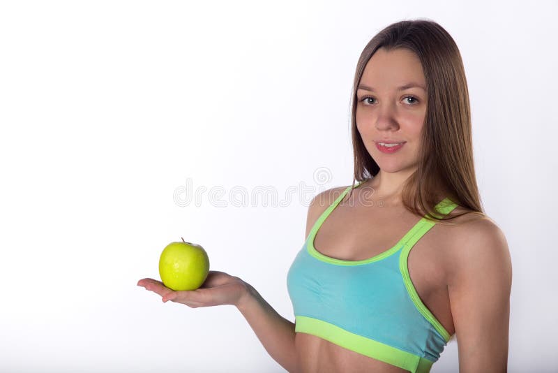 Молодая девушка фитнеса представляет с яблоком и гантелью стоковая фотография rf