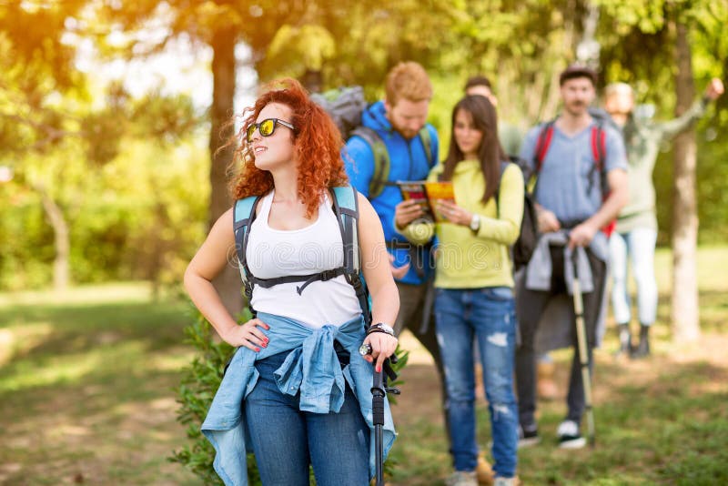 Молодая женщина hiker с группой в составе hikers в древесинах стоковые фото Молодая женщина hiker с группой в составе hikers в древесинах стоковые фото