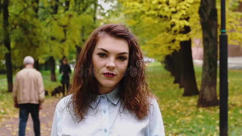Молодая женщина redhead в парке смеясь над на себе сток-видео