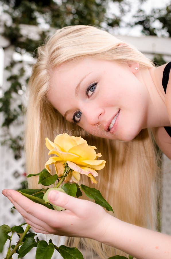 Молодая женщина пахнуть желтым Розой