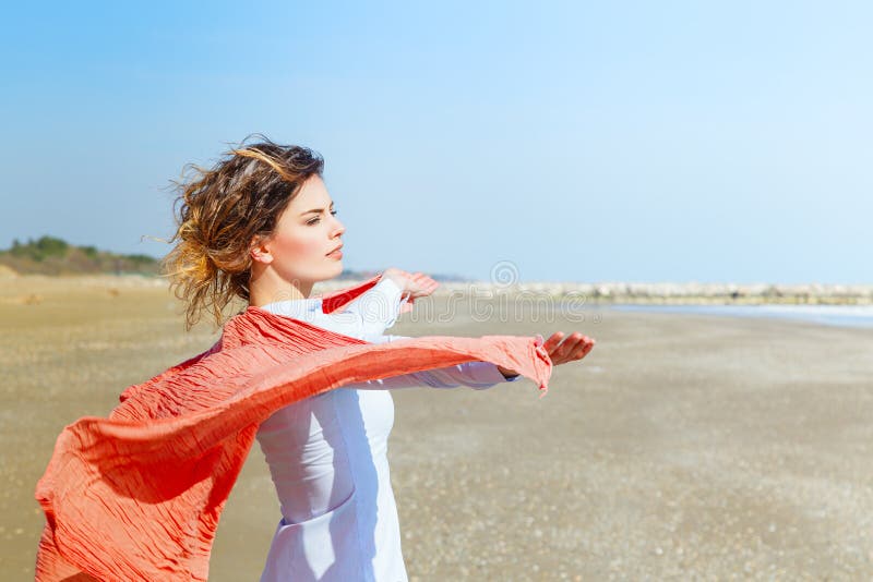 Молодая женщина с красным шарфом на пляже