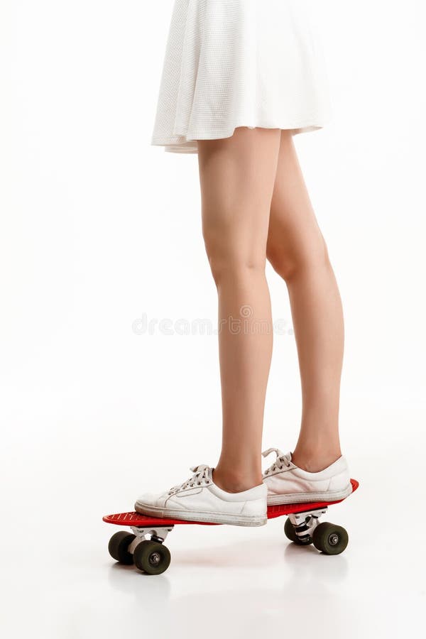 Молодая милая девушка skateboarding над белой предпосылкой конец вверх стоковое изображение rf Молодая милая девушка skateboarding над белой предпосылкой конец вверх стоковое изображение rf