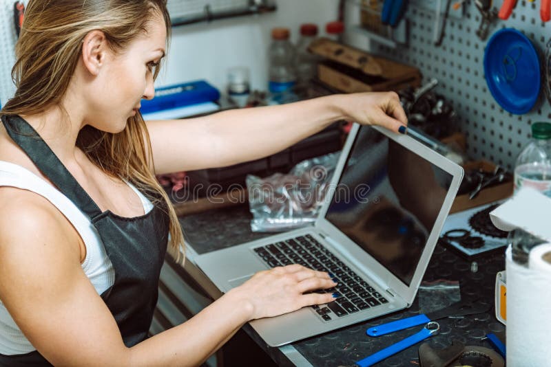 Молодой craftswoman работая используя компьтер-книжку в гараже стоковая фотография rf