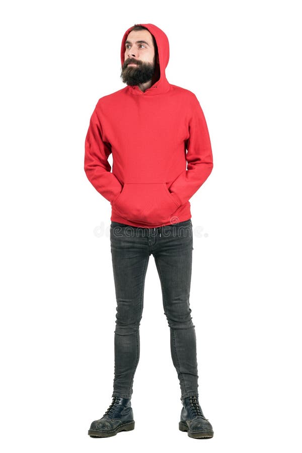 Молодой бородатый человек нося красный hoodie с руками в карманн смотря прочь стоковые изображения rf