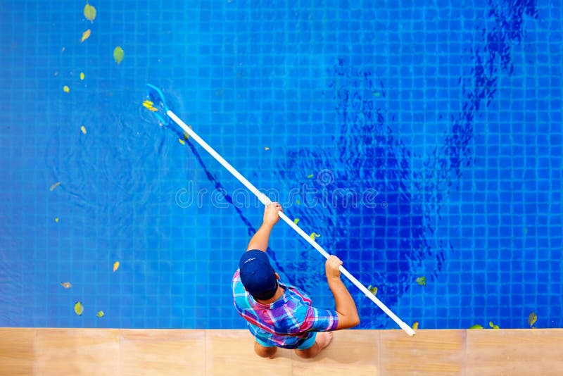 Young adult man, personnel cleaning the pool from leaves, top view. Young adult man, personnel cleaning the pool from leaves, top view