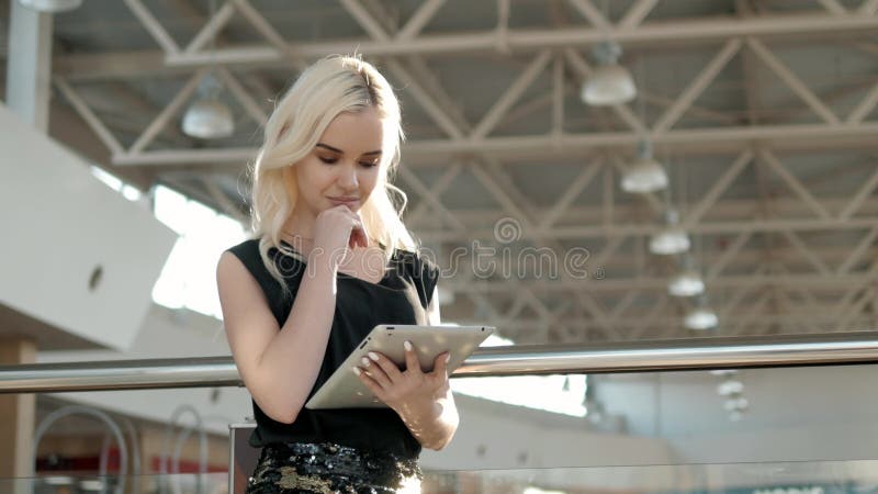 Молодой женский пассажир на авиапорте используя ее планшет пока ждущ полет, красивую женщину девушки внутри стоковое фото Молодой женский пассажир на авиапорте используя ее планшет пока ждущ полет, красивую женщину девушки внутри стоковое фото
