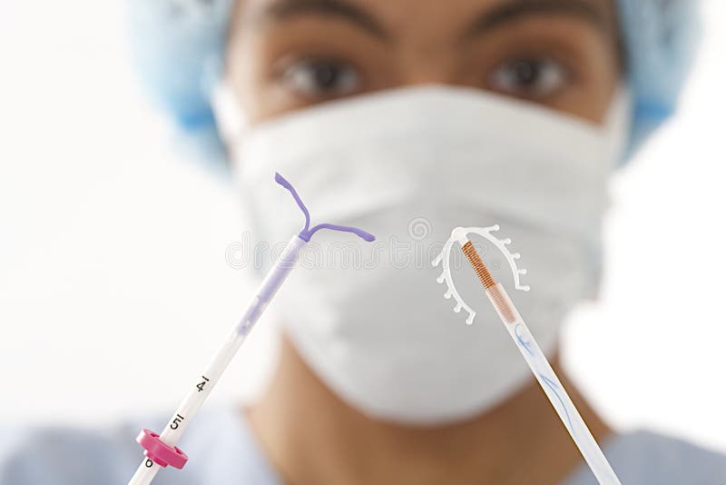 Молодой доктор показывая 2 тип приборов регулирования рождаемости IUD стоковое изображение Молодой доктор показывая 2 тип приборов регулирования рождаемости IUD стоковое изображение