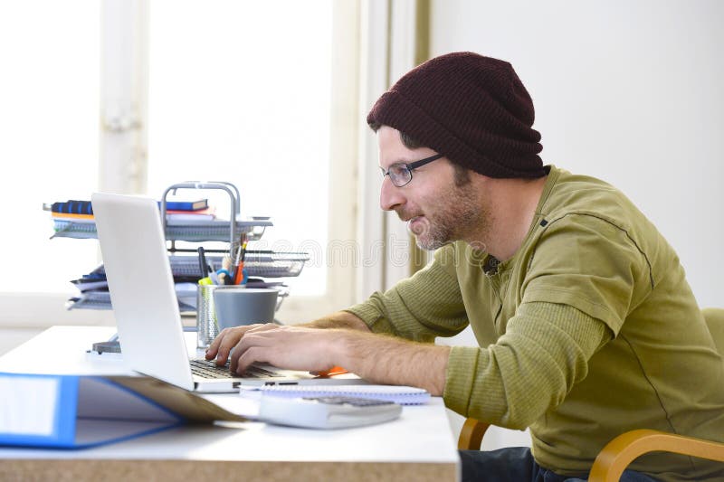 Молодой привлекательный бизнесмен битника работая от домашнего офиса как бизнес модель фрилансера работающий на самого себя стоковое изображение rf Молодой привлекательный бизнесмен битника работая от домашнего офиса как бизнес модель фрилансера работающий на самого себя стоковое изображение rf