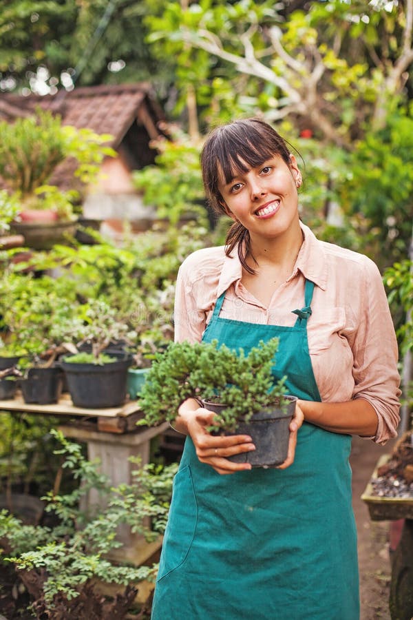 young female gardener holding bonsai. young female gardener holding bonsai