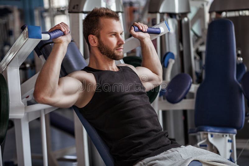 Young man with weight training equipment in sport gym. Young man with weight training equipment in sport gym