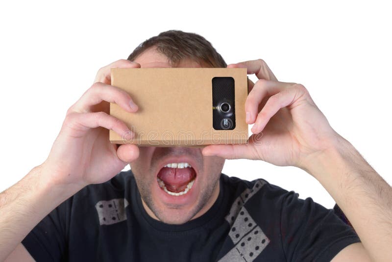 Молодой человек использует виртуальную реальность (картон VR) изолированный на белой предпосылке стоковая фотография rf Молодой человек использует виртуальную реальность (картон VR) изолированный на белой предпосылке стоковая фотография rf