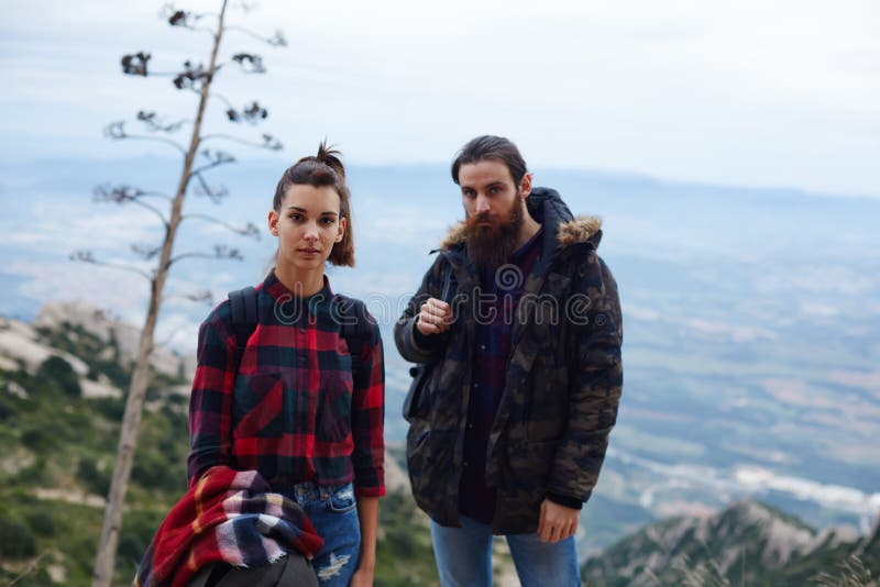 Молодые hikers отдыхая после долгого пути стоя на горе стоковая фотография Молодые hikers отдыхая после долгого пути стоя на горе стоковая фотография
