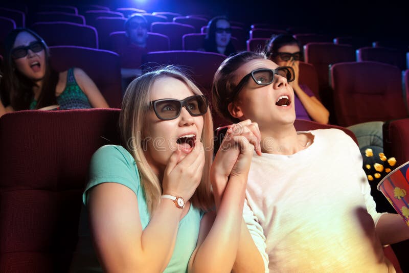 Young couple sitting at the cinema, watching a horrors film. Cinema photo series. Young couple sitting at the cinema, watching a horrors film. Cinema photo series