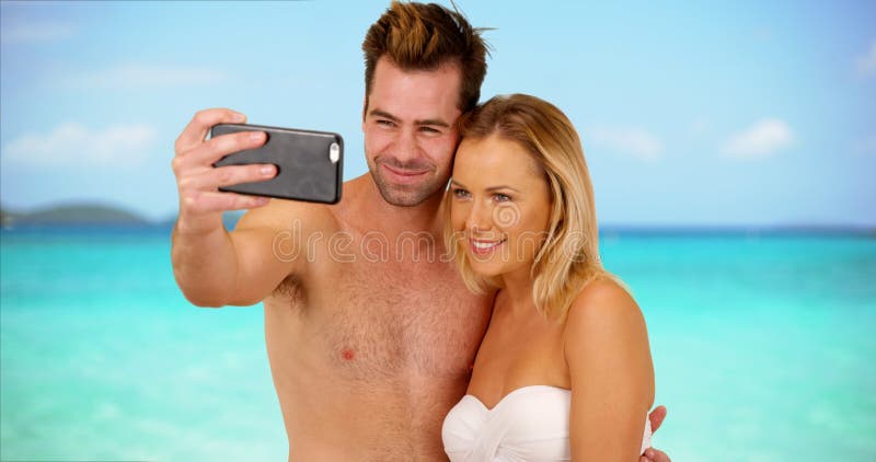 Молодые социальные средства массовой информации преследовали пар принимая selfies к столбу онлайн стоковое изображение Молодые социальные средства массовой информации преследовали пар принимая selfies к столбу онлайн стоковое изображение