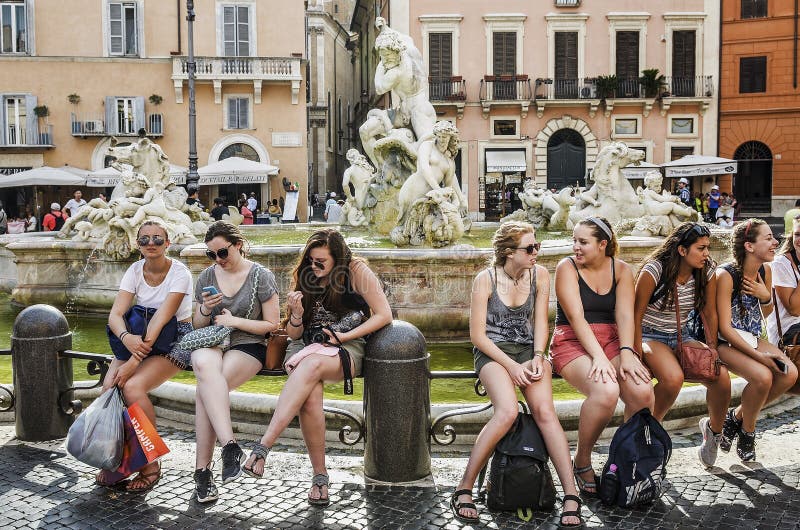 Молодые туристы посещая фонтан в аркаде Navona стоковая фотография Молодые туристы посещая фонтан в аркаде Navona стоковая фотография