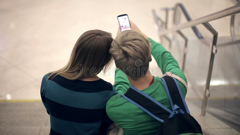 Молодые любящие пары принимают selfie сидя на шагах коллежа видеоматериал