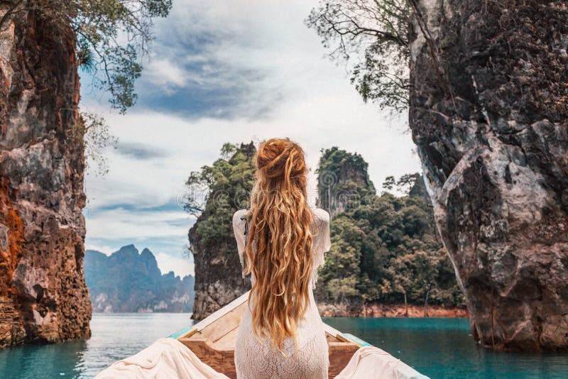 Модная молодая модель в платье стиля boho на шлюпке на озере стоковые изображения