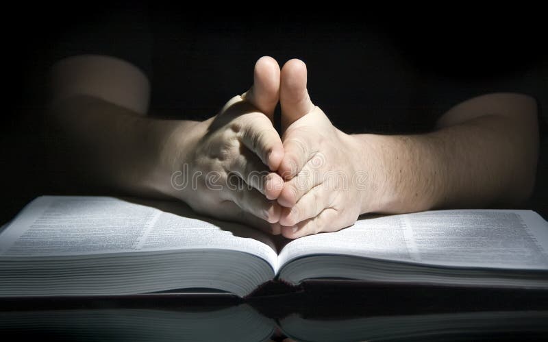 A man sitting at a table, his hands in a praying gesture. A man sitting at a table, his hands in a praying gesture.