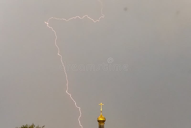 Молния во время грозы в небе над куполом и чр стоковое фото