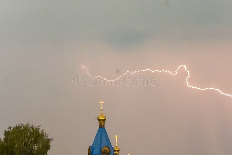Молния во время грозы в небе над куполом и чр стоковые фото