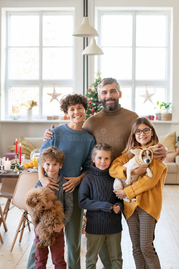 Молодая большая счастливая семья родителей 3 детей и 2 красивых животных стоковое изображение rf