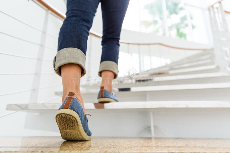 Young adult woman walking up the stairs with sun sport background. Young adult woman walking up the stairs with sun sport background.