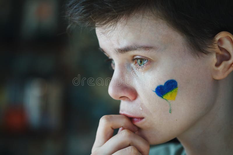 молодая грустная женщина с символом украинского флага на её лице плачет стоковые фотографии rf